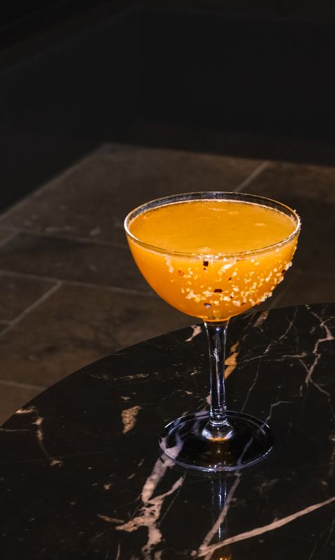 Golden Heat Margarita, amber cocktail with chilli-salt rim